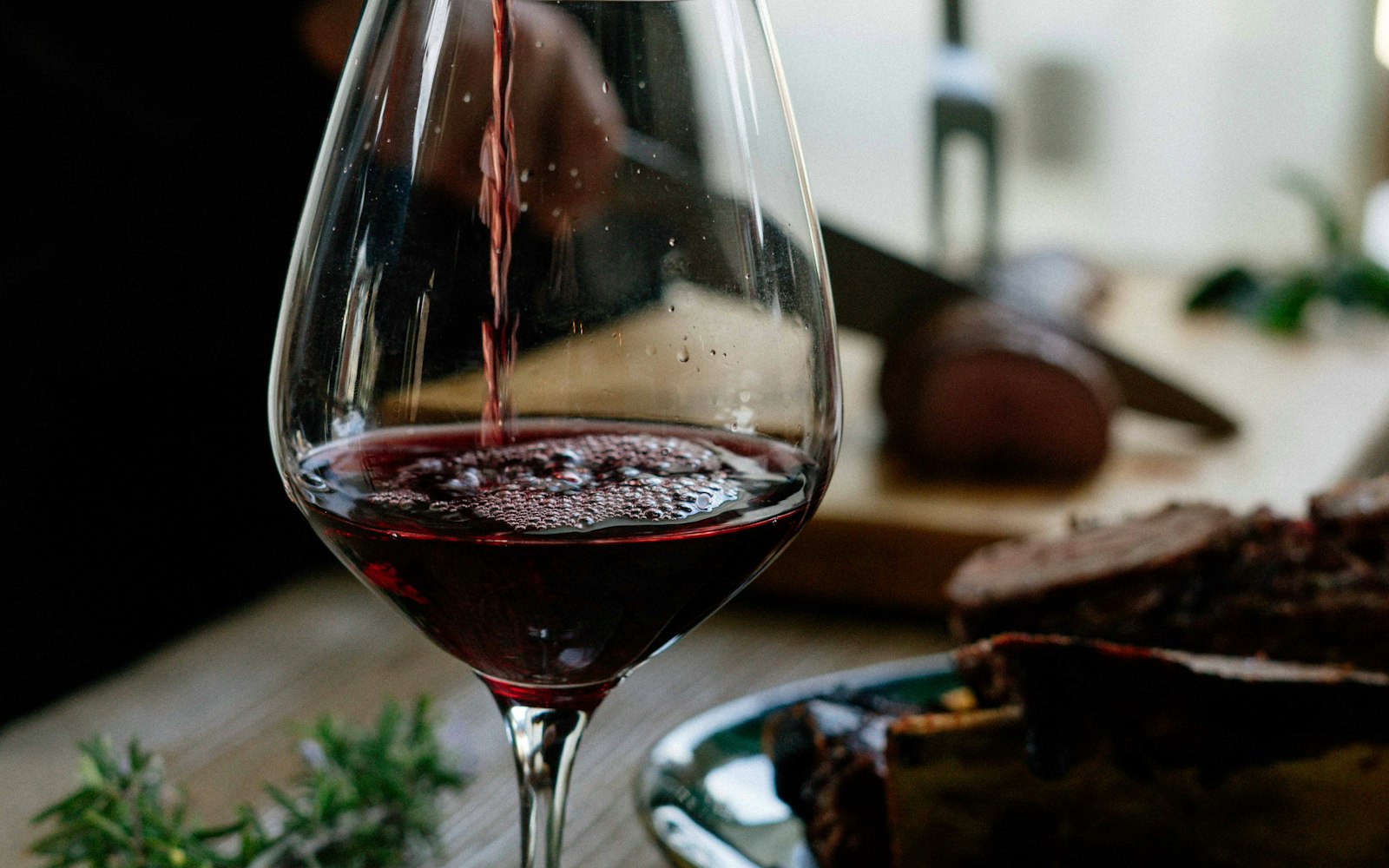 Red wine pouring into a glass — everyday Greek bottles offer remarkable value