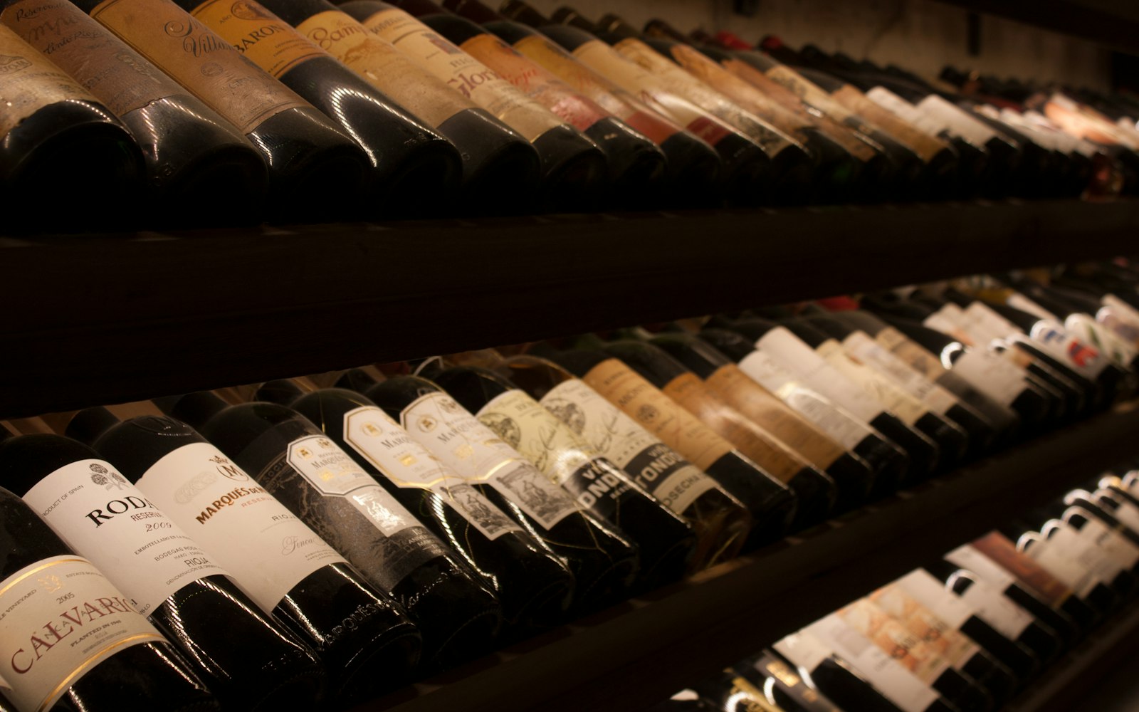 Wine bottles arranged on a wooden shelf